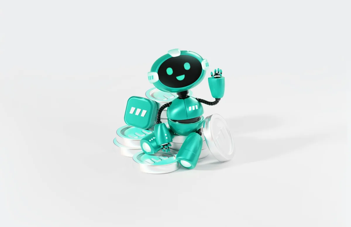 A teal toy robot waving while sitting on a stack of silver coins against a light background